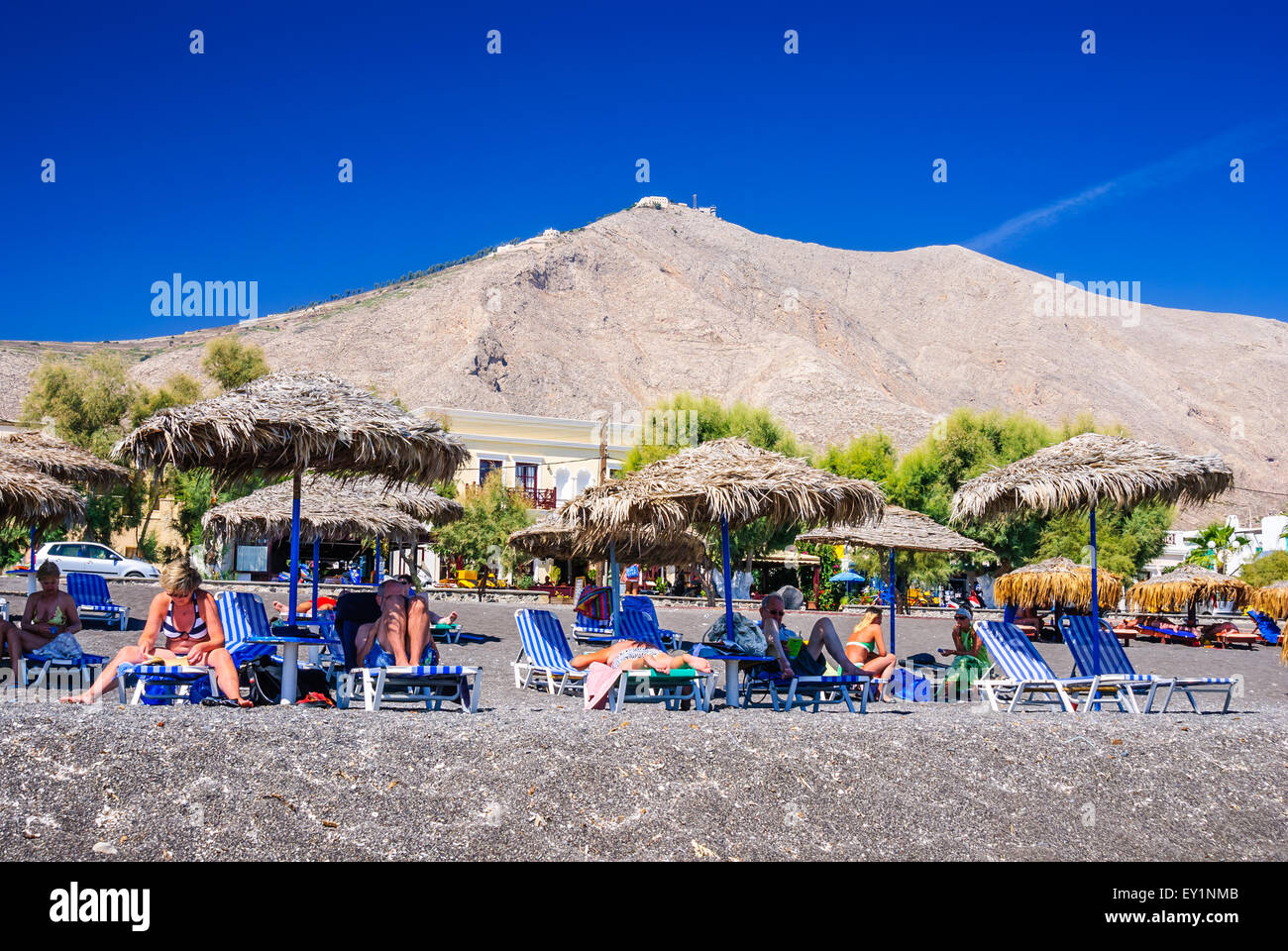 SANTORINI, GREECE - 19 SEPTEMBER 2010: People sunbathing and swimming at Black Beach of Kamari in Santorini, Greece. Stock Photo