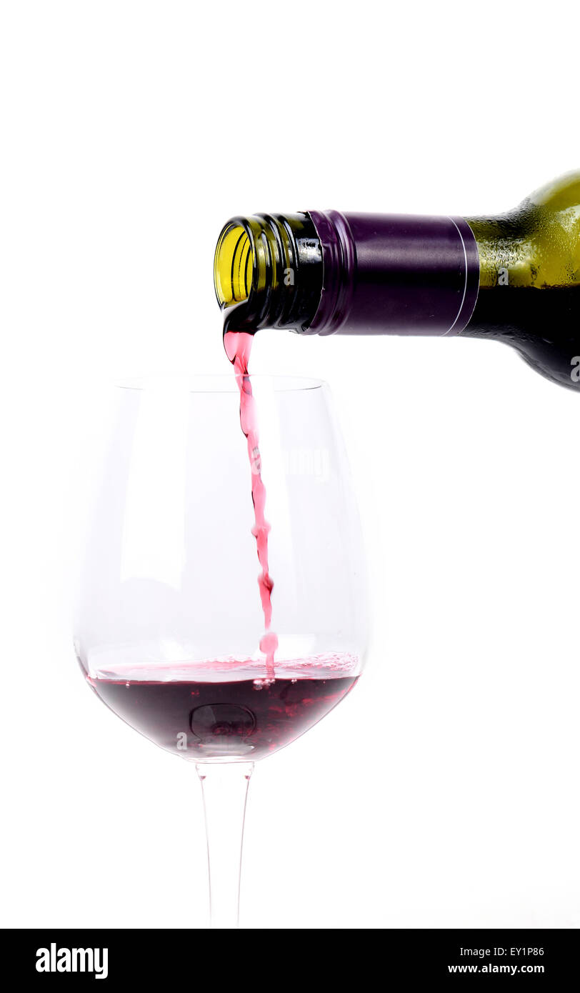 Red wine pouring into a glass on white background Stock Photo