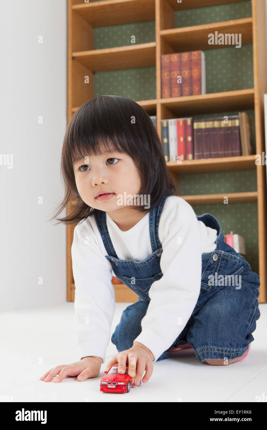 Little girl sitting and playing with toy car Stock Photo - Alamy