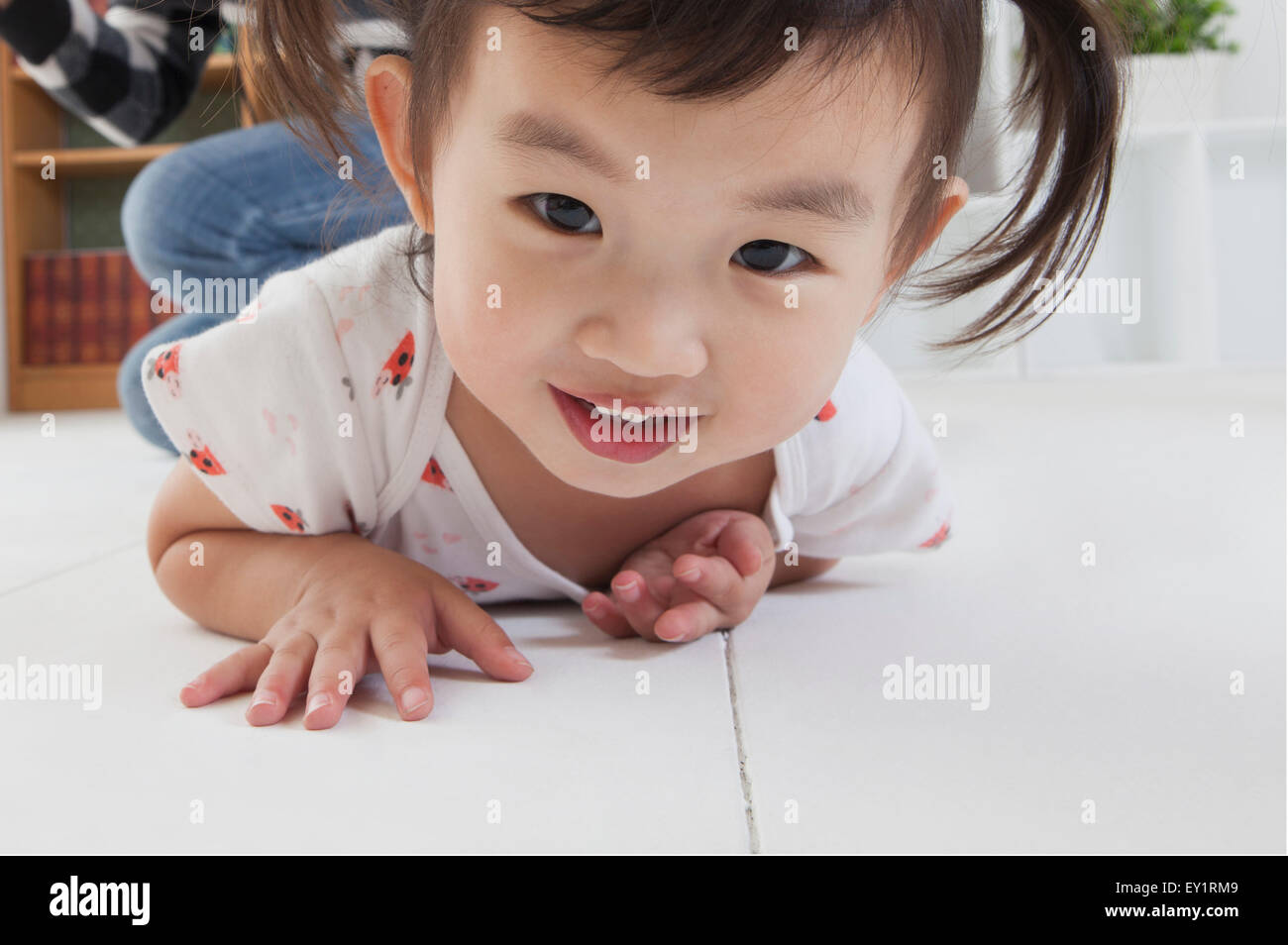 Little girl lying down on front and smiling happily Stock Photo Alamy