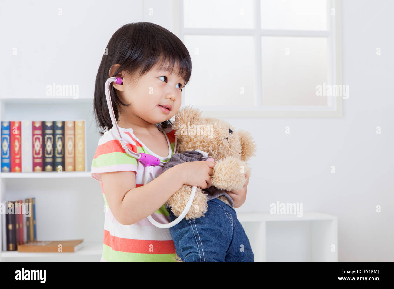 Little girl holding teddy bear and looking away Stock Photo - Alamy