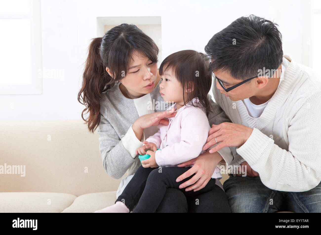 Father and mother looking at baby girl together, Stock Photo