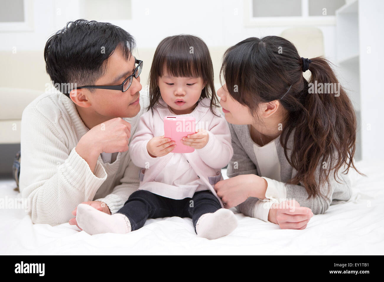 Father and mother looking at baby girl together, Stock Photo