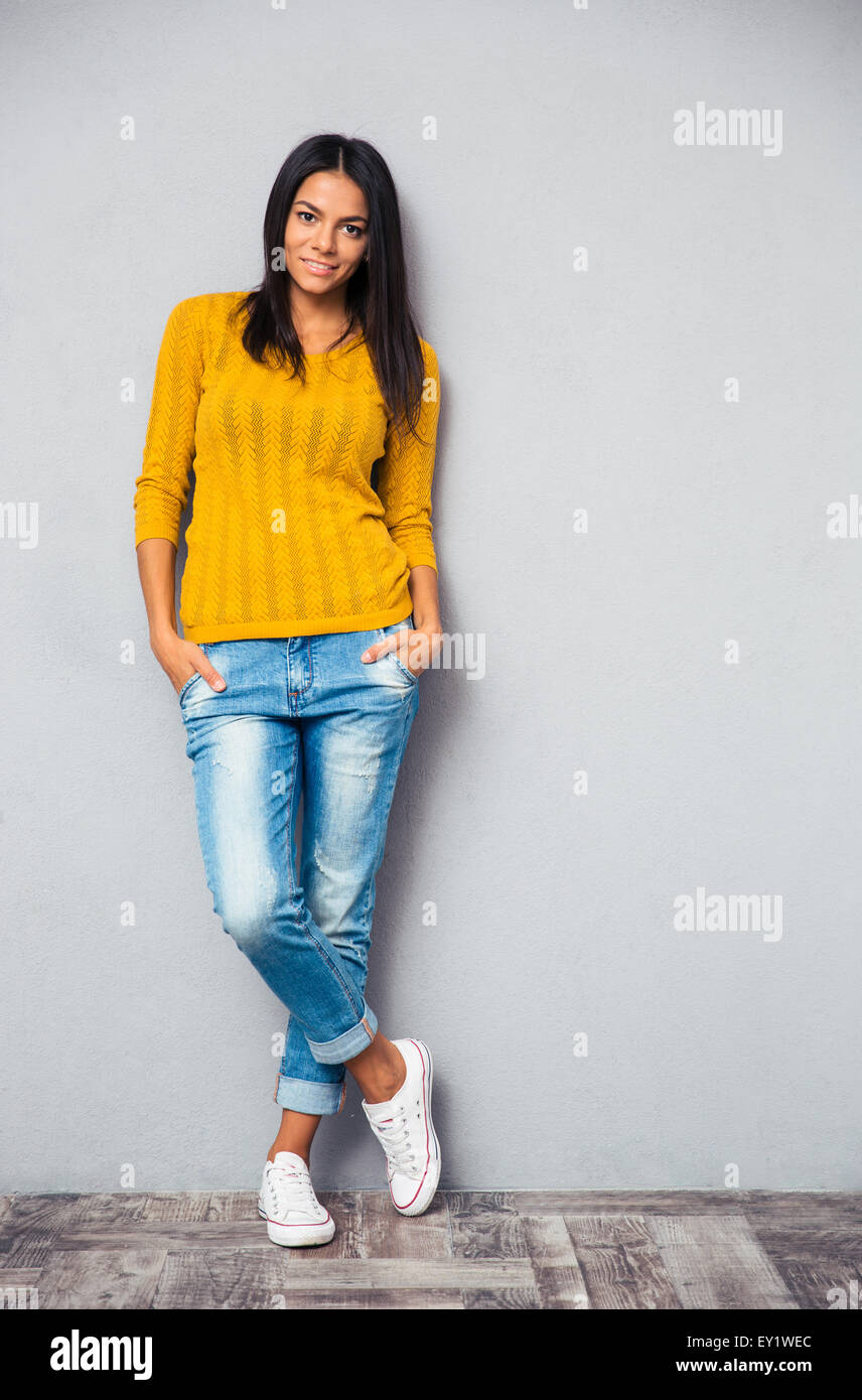Full length portrait of a casual fashion woman standing on gray ...