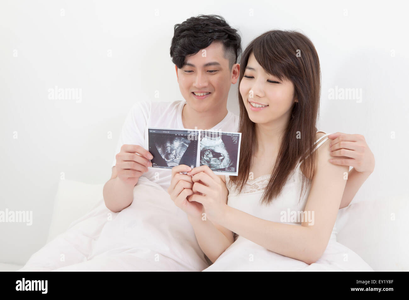 Young couple holding pics with smile, Stock Photo