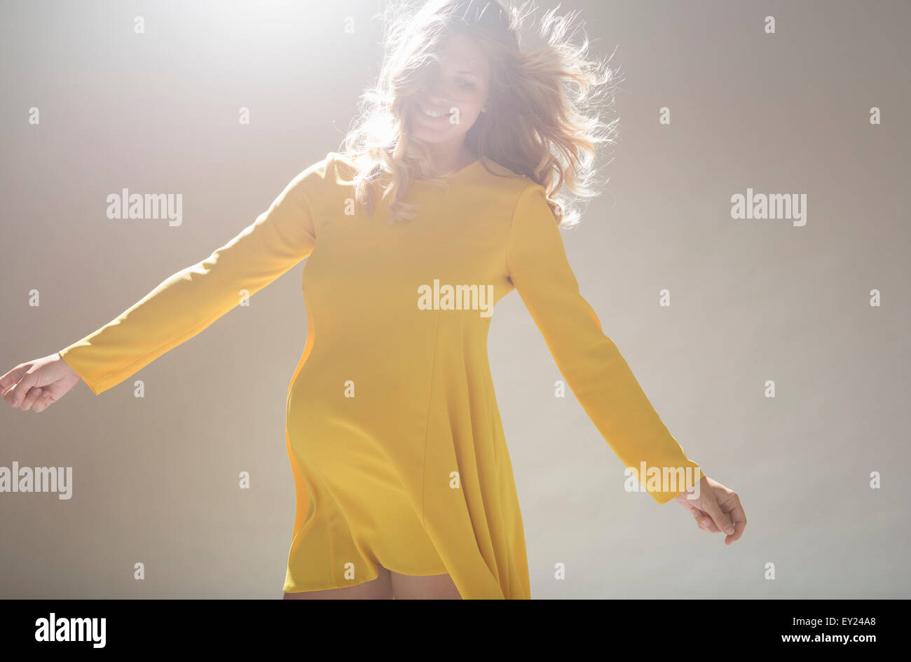 Studio portrait of pregnant young woman twirling around Stock Photo