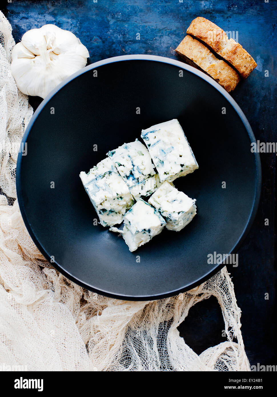 Garlic bulb and bowl of cubed blue cheese Stock Photo