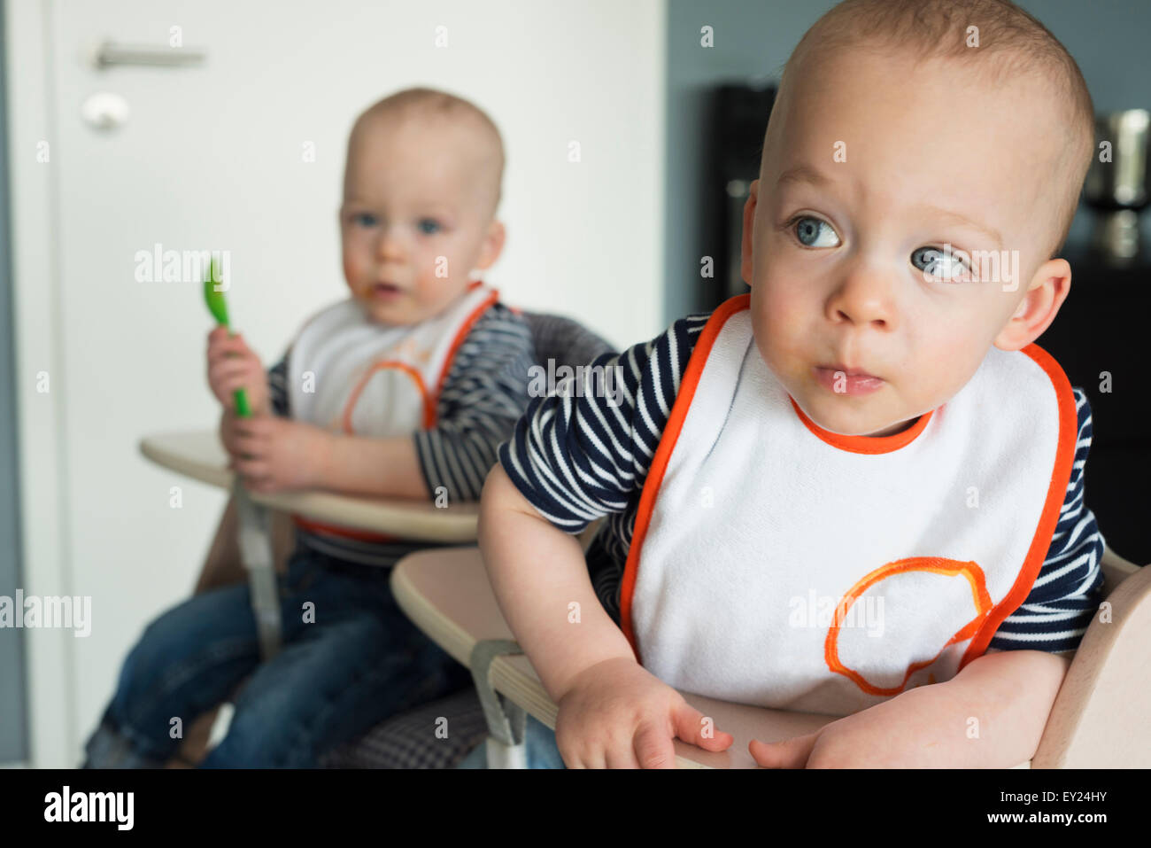 Baby twin brothers playing in high chairs Stock Photo Alamy