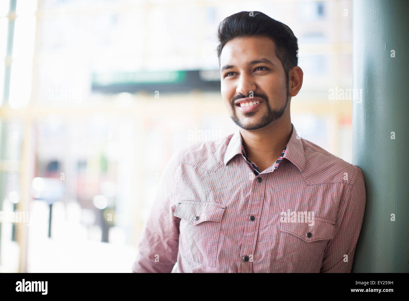 Portrait of young man leaning against wall on street Stock Photo - Alamy