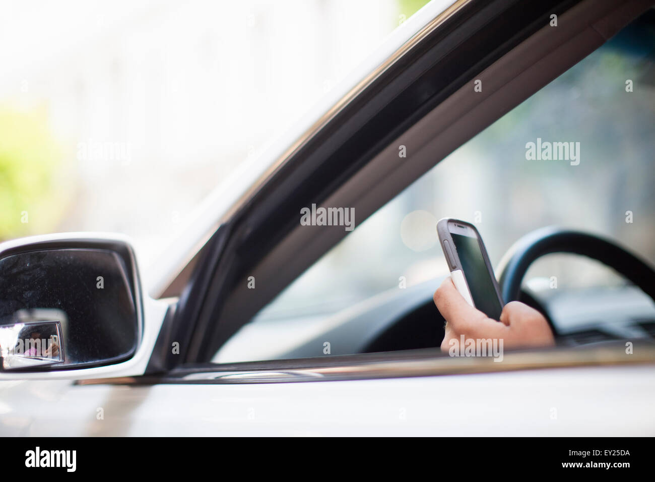Hand of businessman using smartphone at car window Stock Photo