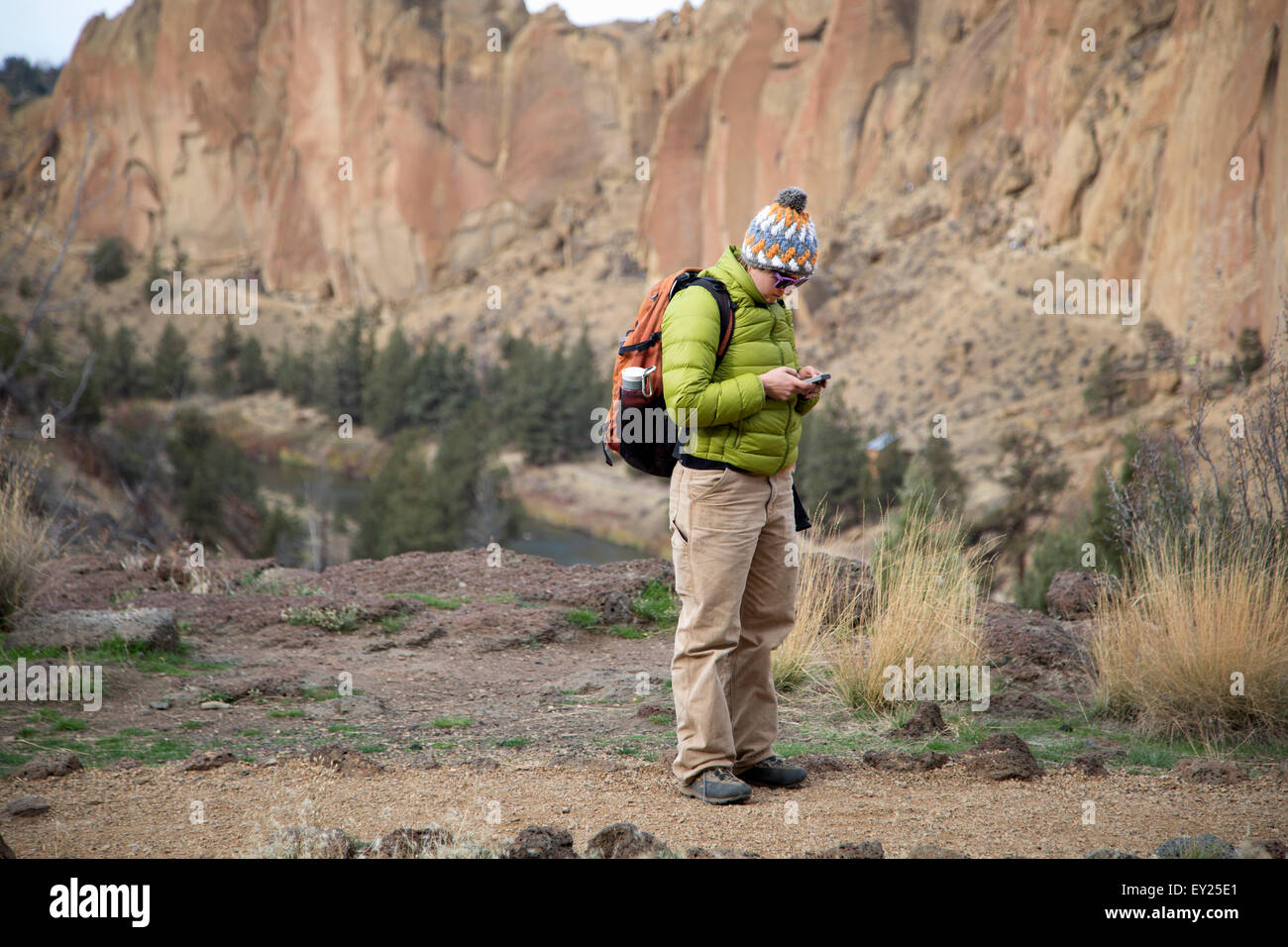 Hiker checking phone, Smith Rock State Park, Oregon, US Stock Photo