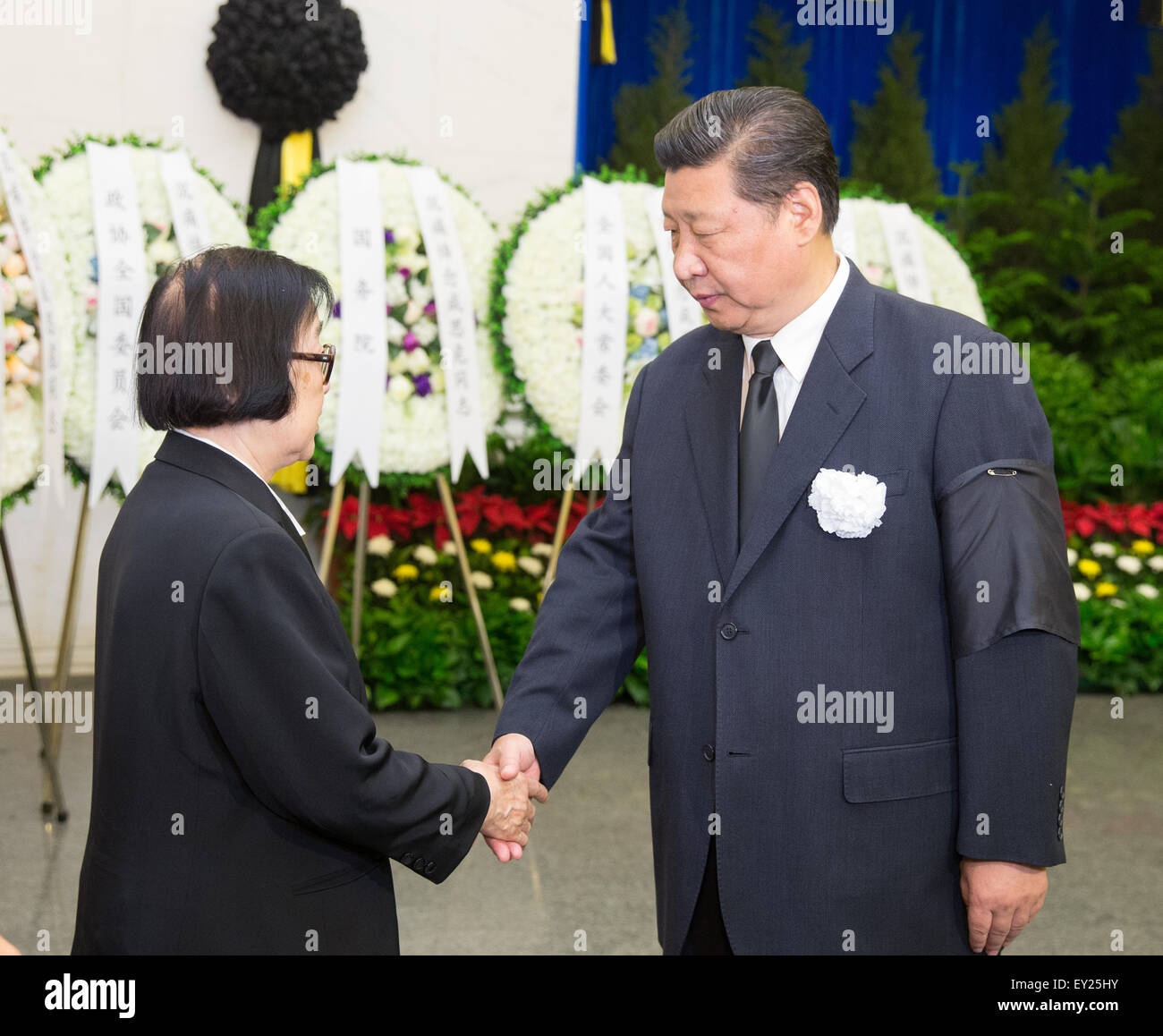 Beijing, China. 20th July, 2015. Chinese President Xi Jinping (R) shakes hands with a family member of Cheng Siwei, a renowned Chinese economist and former vice chairman of the Standing Committee of China's National People's Congress, at Cheng's funeral at Babaoshan Revolutionary Cemetery in Beijing, capital of China, July 20, 2015. Chinese top leaders Xi Jinping, Li Keqiang, Zhang Dejiang, Yu Zhengsheng, Liu Yunshan, Wang Qishan and Zhang Gaoli, attended the funeral here on Monday morning. Credit:  Huang Jingwen/Xinhua/Alamy Live News Stock Photo