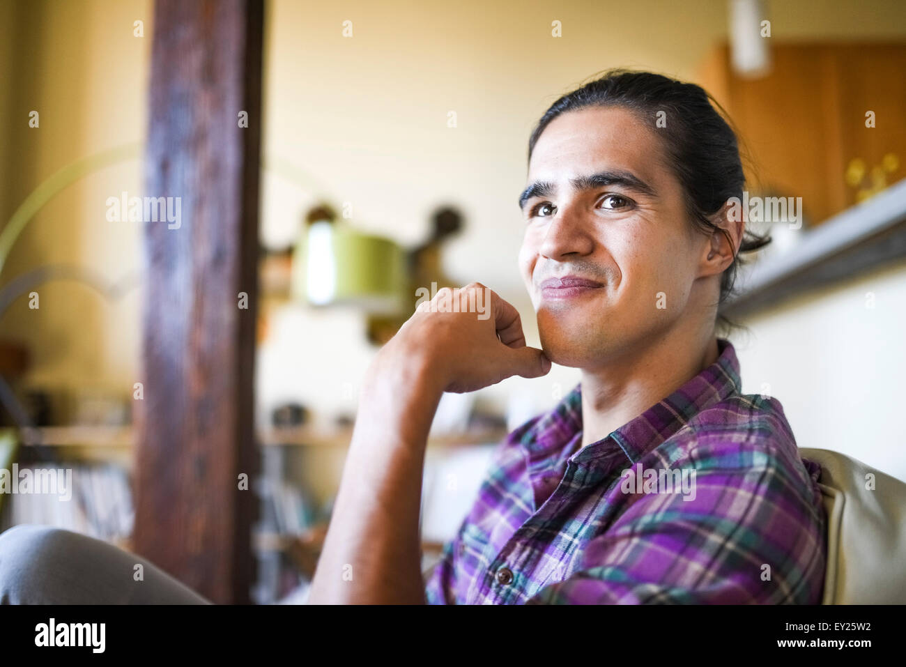 Portrait of young man sitting indoors relaxing Stock Photo