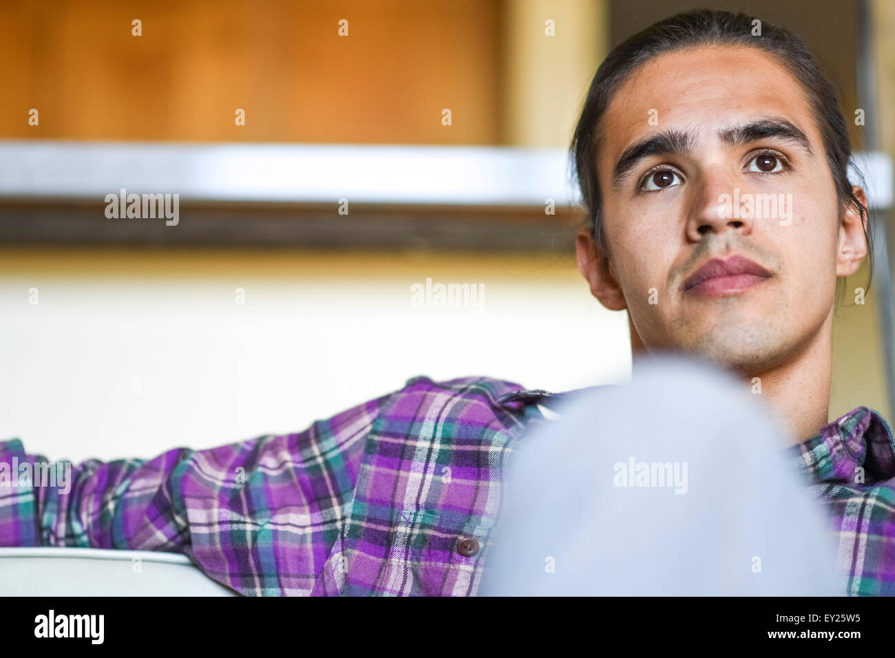 Portrait of young man sitting indoors relaxing Stock Photo
