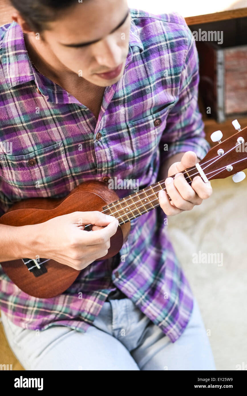 Young man playing ukulele, elevated view Stock Photo