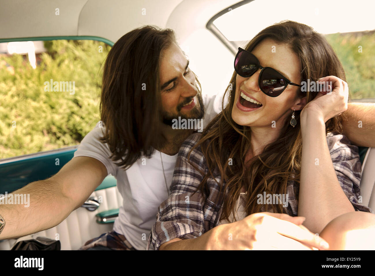 Young couple laughing in back seat of car Stock Photo