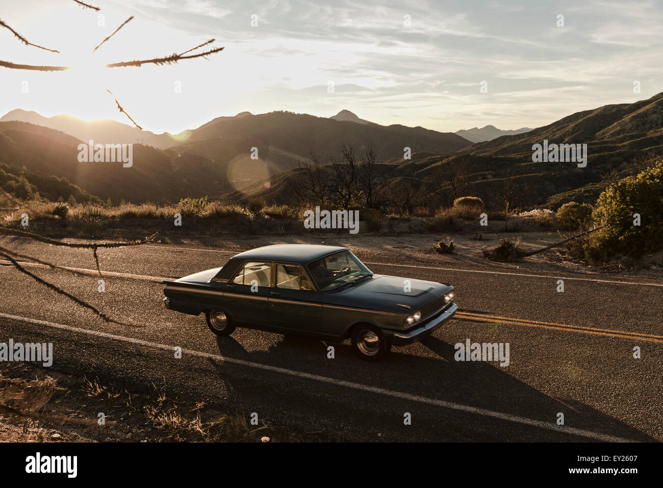 Young man driving vintage car on road trip in desert, Los Angeles, California, USA Stock Photo