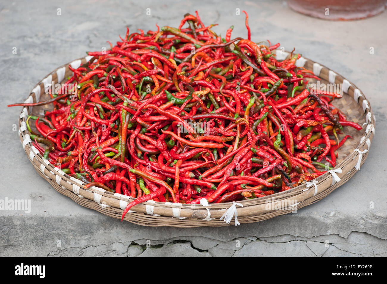 Red pepper drying outdoors in a basket - Chongzhou, Sichuan Province, China Stock Photo