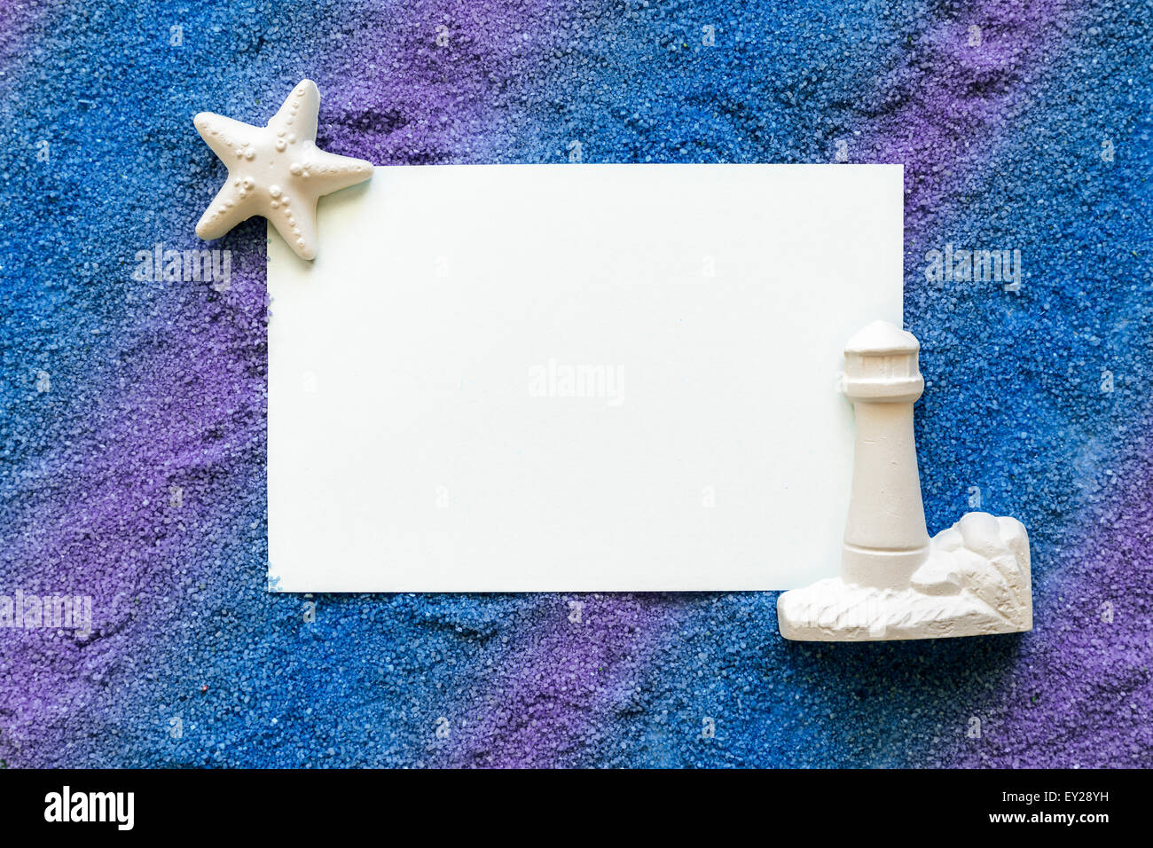 note on blue and violet sand with lighthouse and starfish Stock Photo