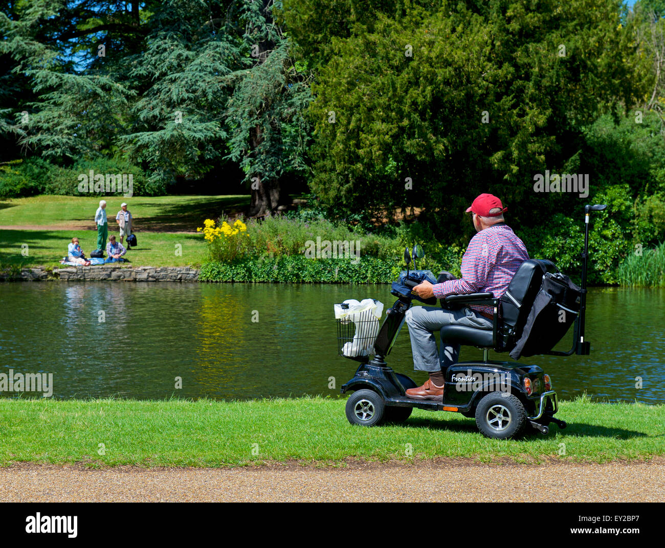 Senior man on mobility scooter looking across the River Avon, Stratford