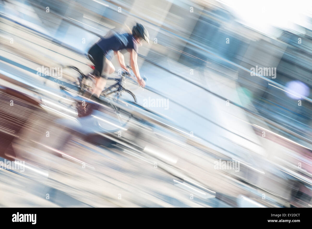 Cyclist speeding through urban sunshine Stock Photo - Alamy