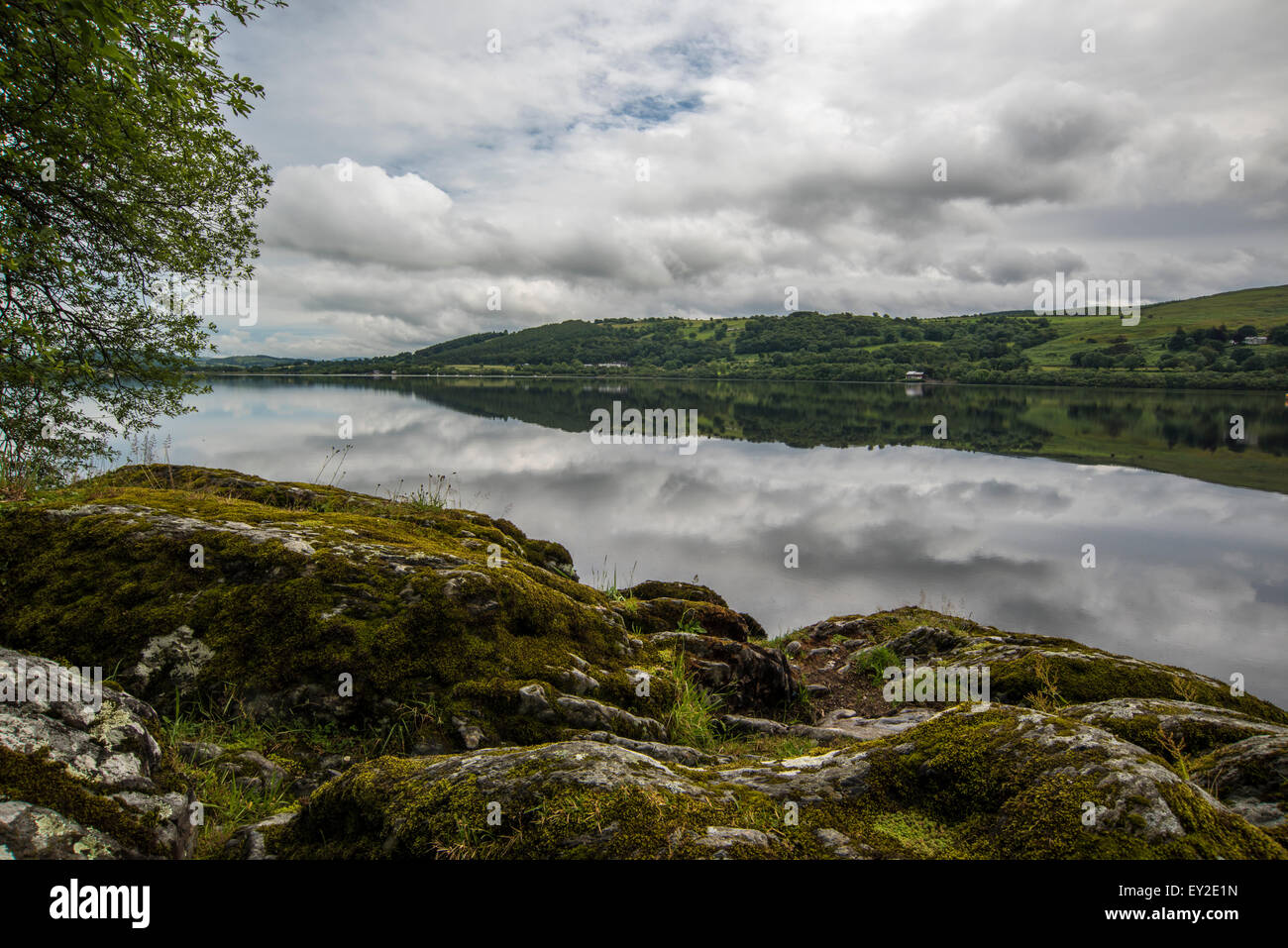 Bala Lake looking over rocks to reflections of clouds in the water