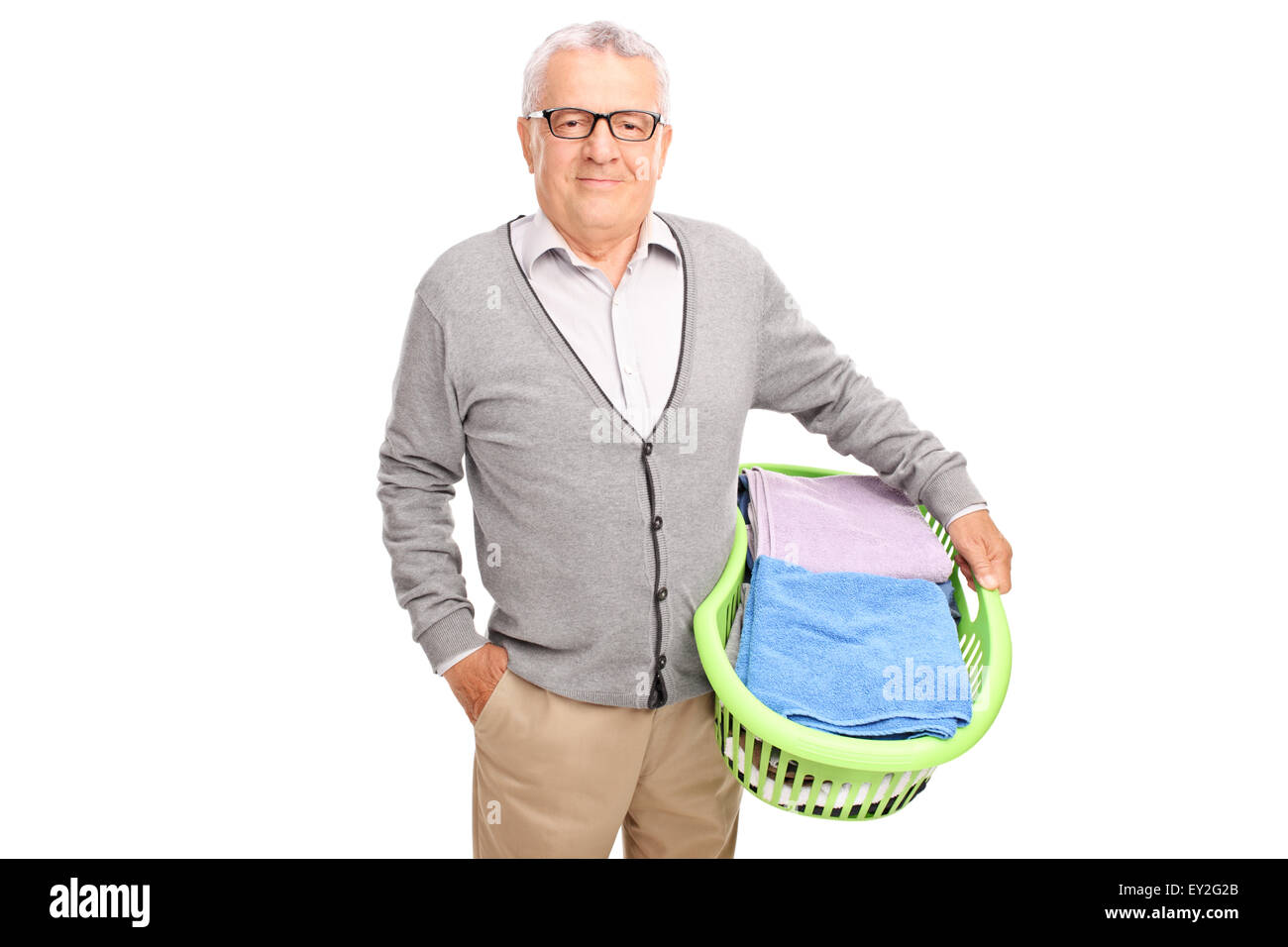 Cheerful senior man holding a laundry basket and looking at the camera isolated on white background Stock Photo