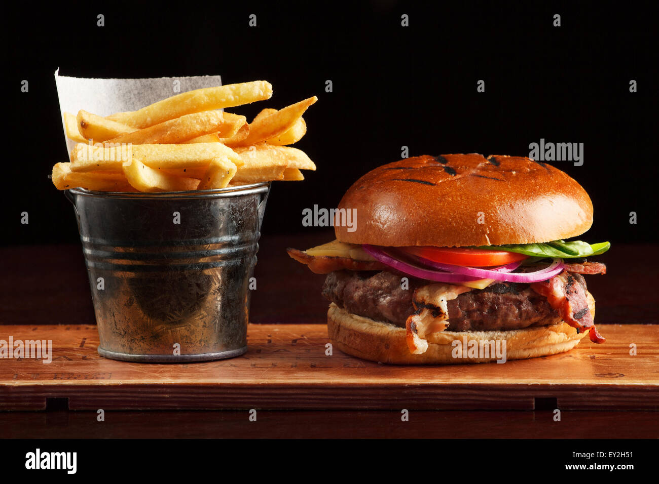 Cheese burger and French fries served on a wooden board Stock Photo Alamy