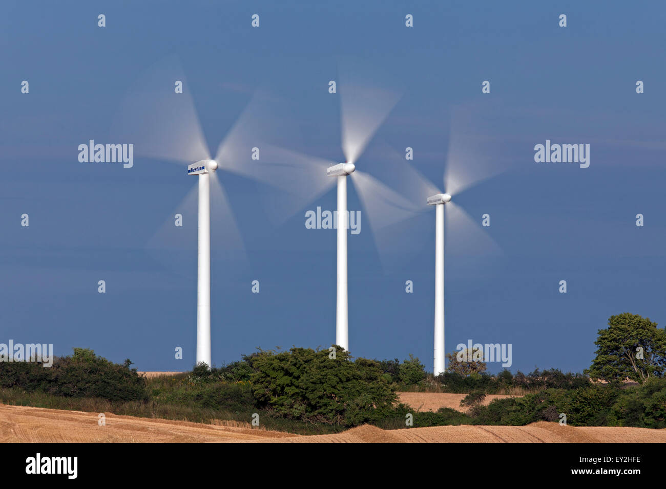 Spinning rotor blades of wind turbines at wind farm against stormy sky Stock Photo Alamy
