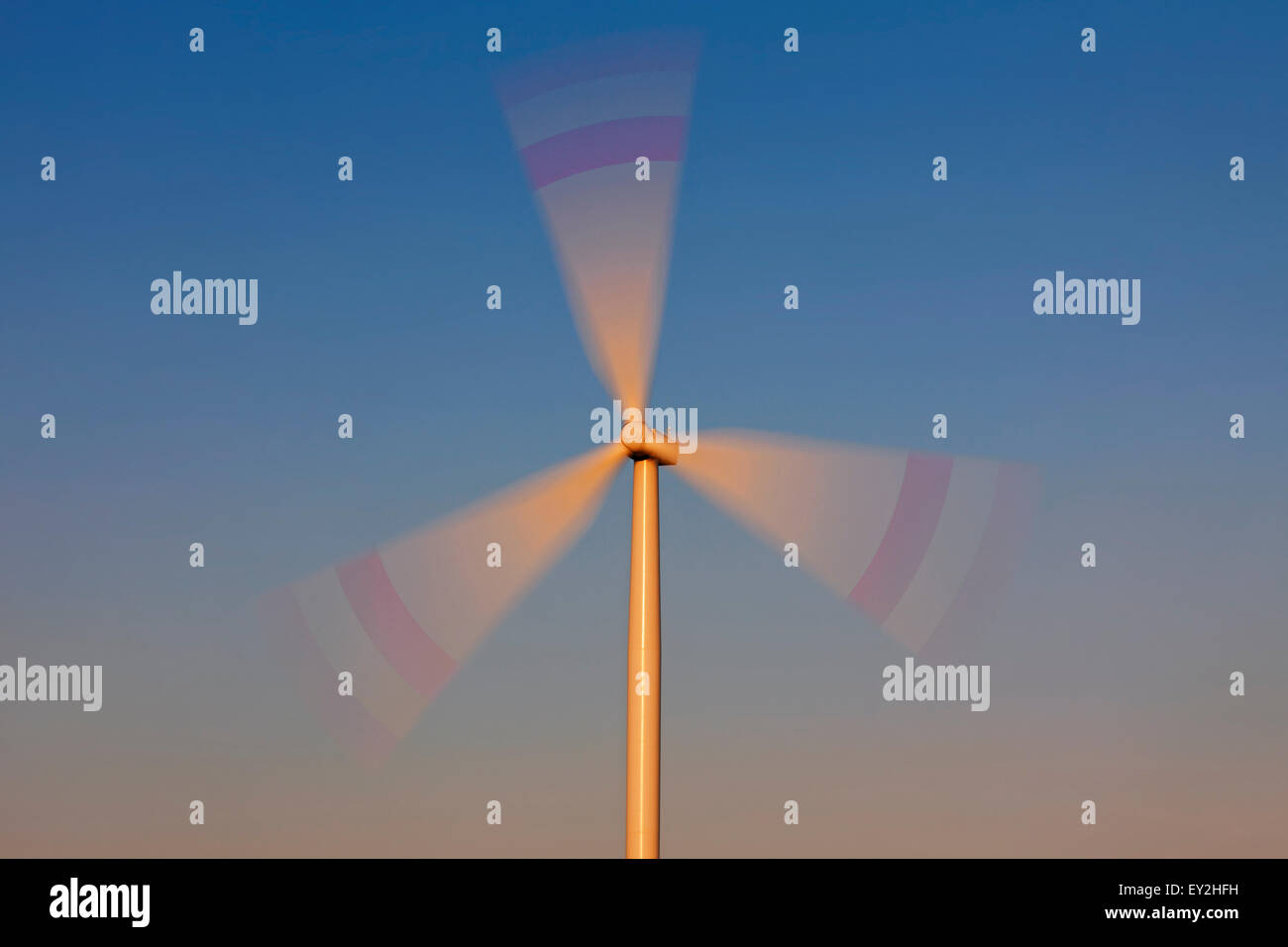 Spinning rotor blades of wind turbine against blue sky Stock Photo Alamy