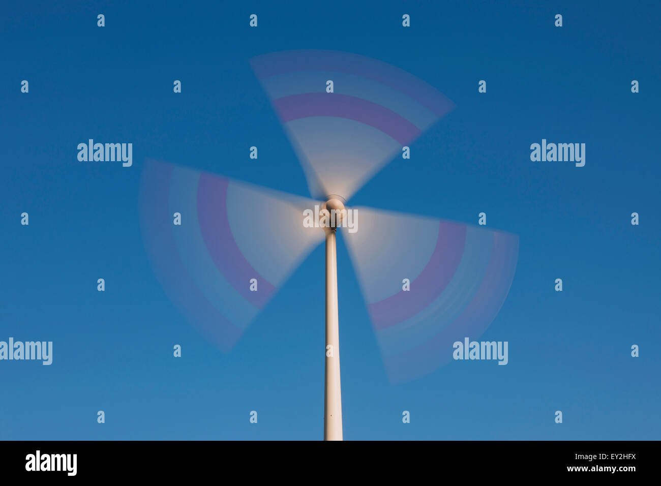 Spinning rotor blades of wind turbine against blue sky Stock Photo Alamy