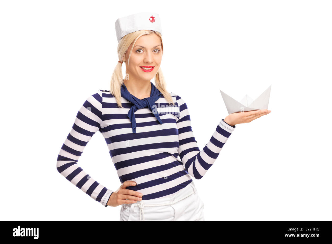 Young female sailor holding a small paper boat and looking at the ...