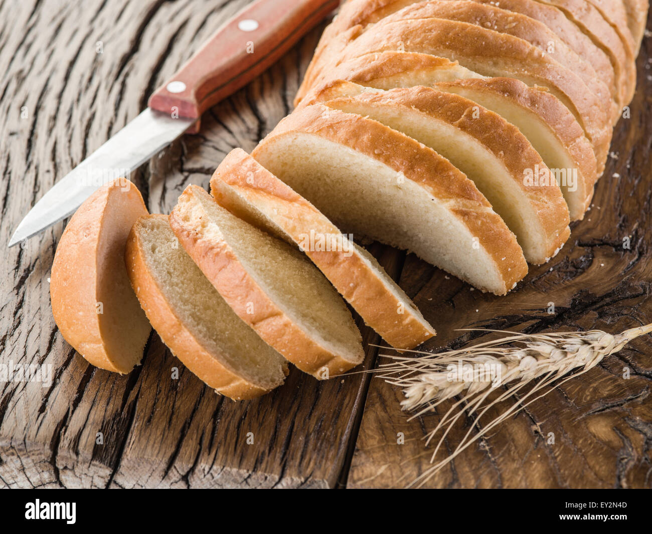 Sliced white bread on the old wooden plank. Stock Photo