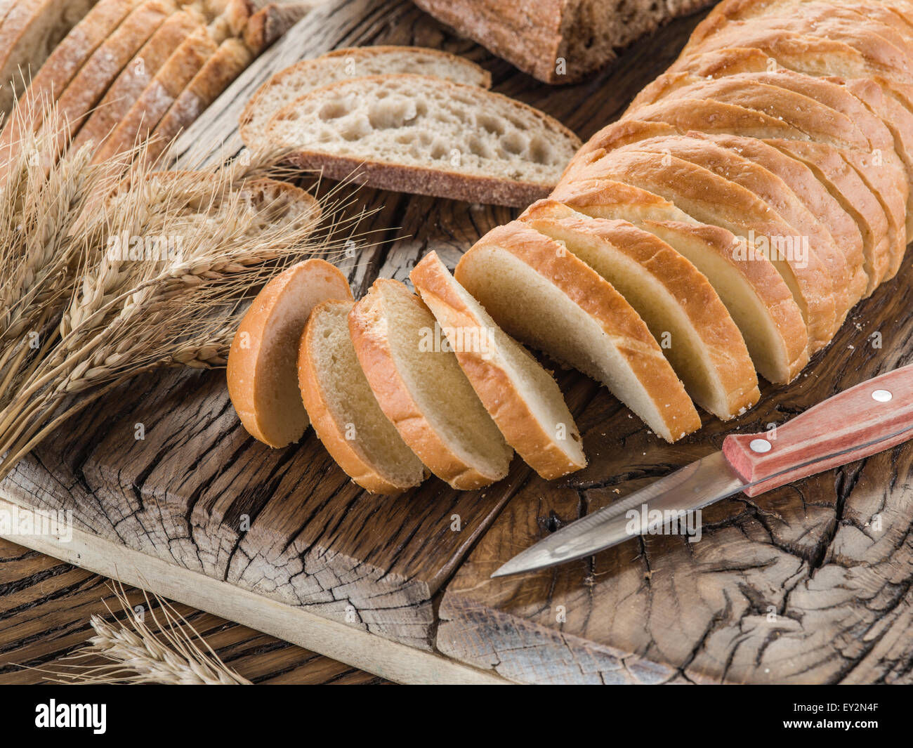 Sliced white bread on the old wooden plank. Stock Photo