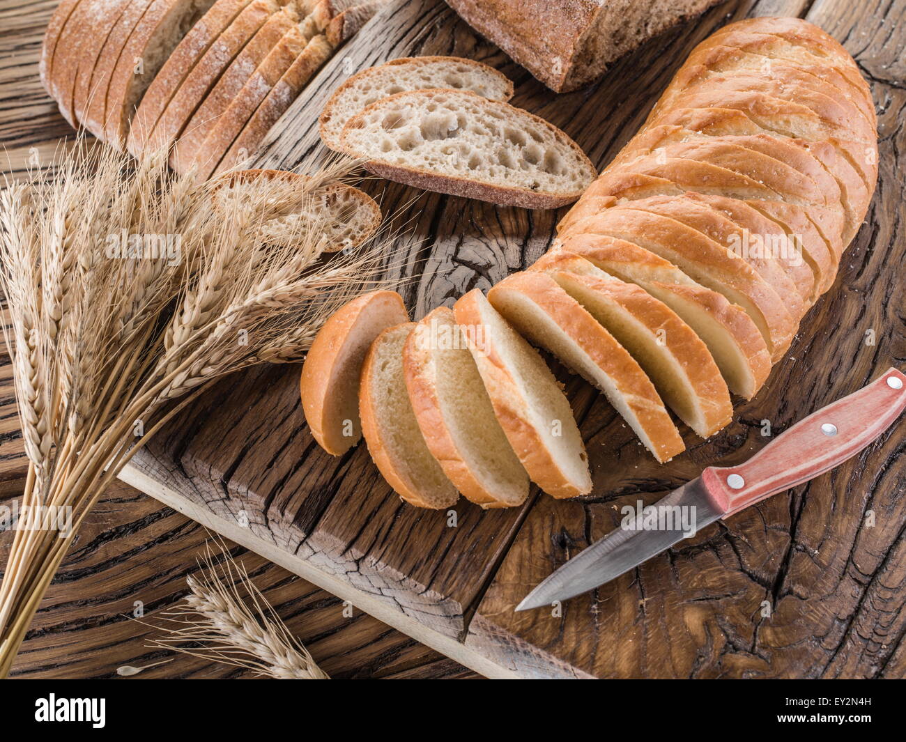 Sliced white bread on the old wooden plank. Stock Photo