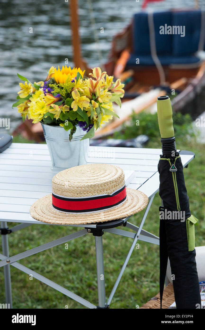 Straw boater hat umbrella and flowers at the Thames Traditional Boat Festival, Fawley Meadows, Henley On Thames, England Stock Photo