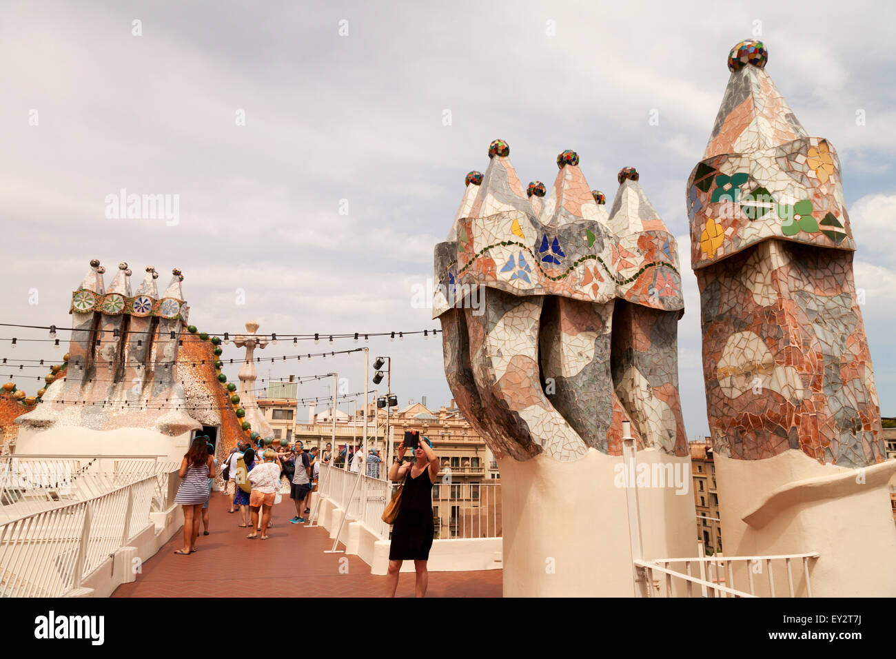 Tourists on the roof of Gaudi's Casa Batllo looking at the colourful chimneys, Casa Batllo, Gracia district, Barcelona Spain Stock Photo