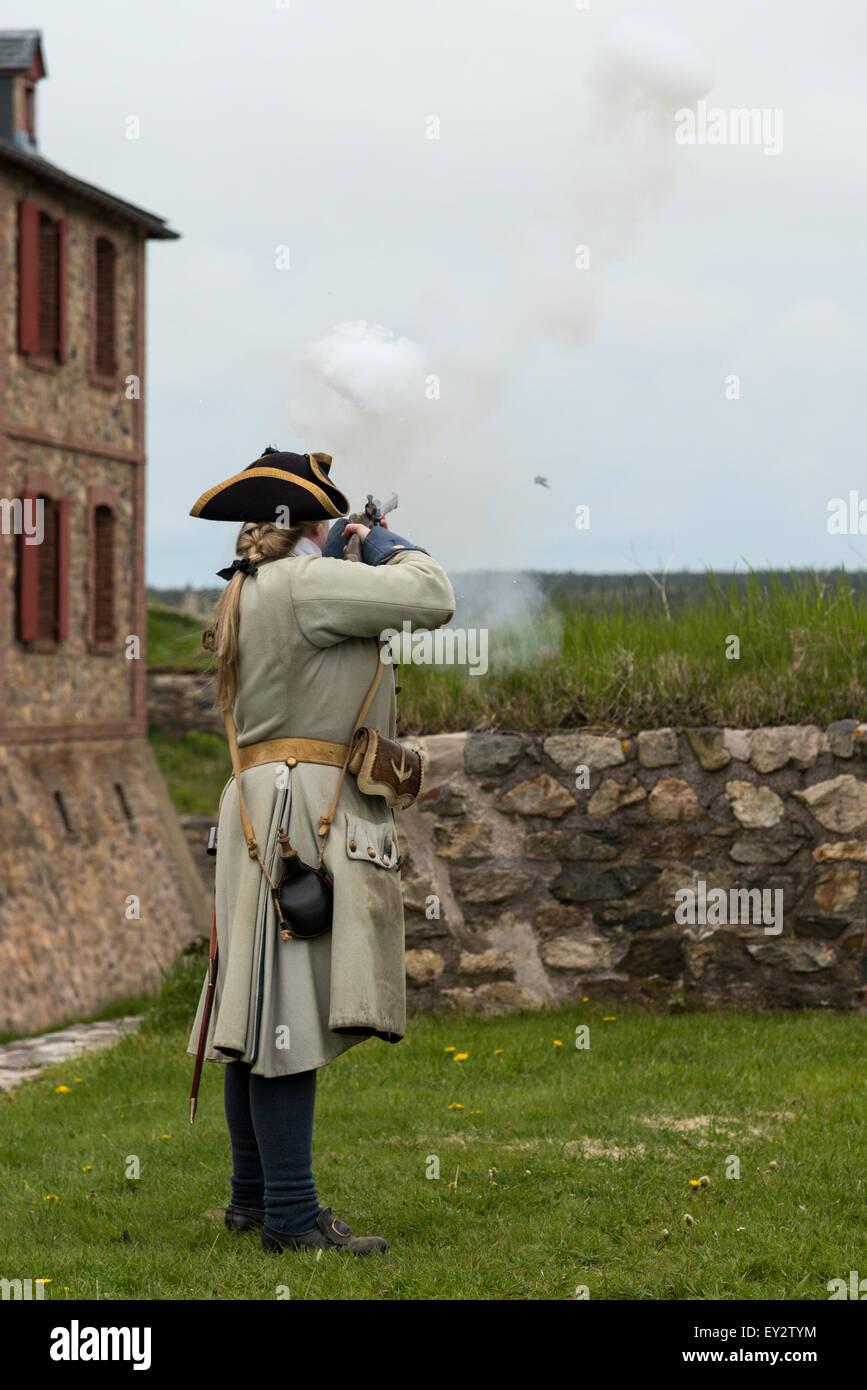 Tour guide firing her weapon at Fortress Louisbourg, Louisbourg, Nova Scotia, Canada - Stock Image