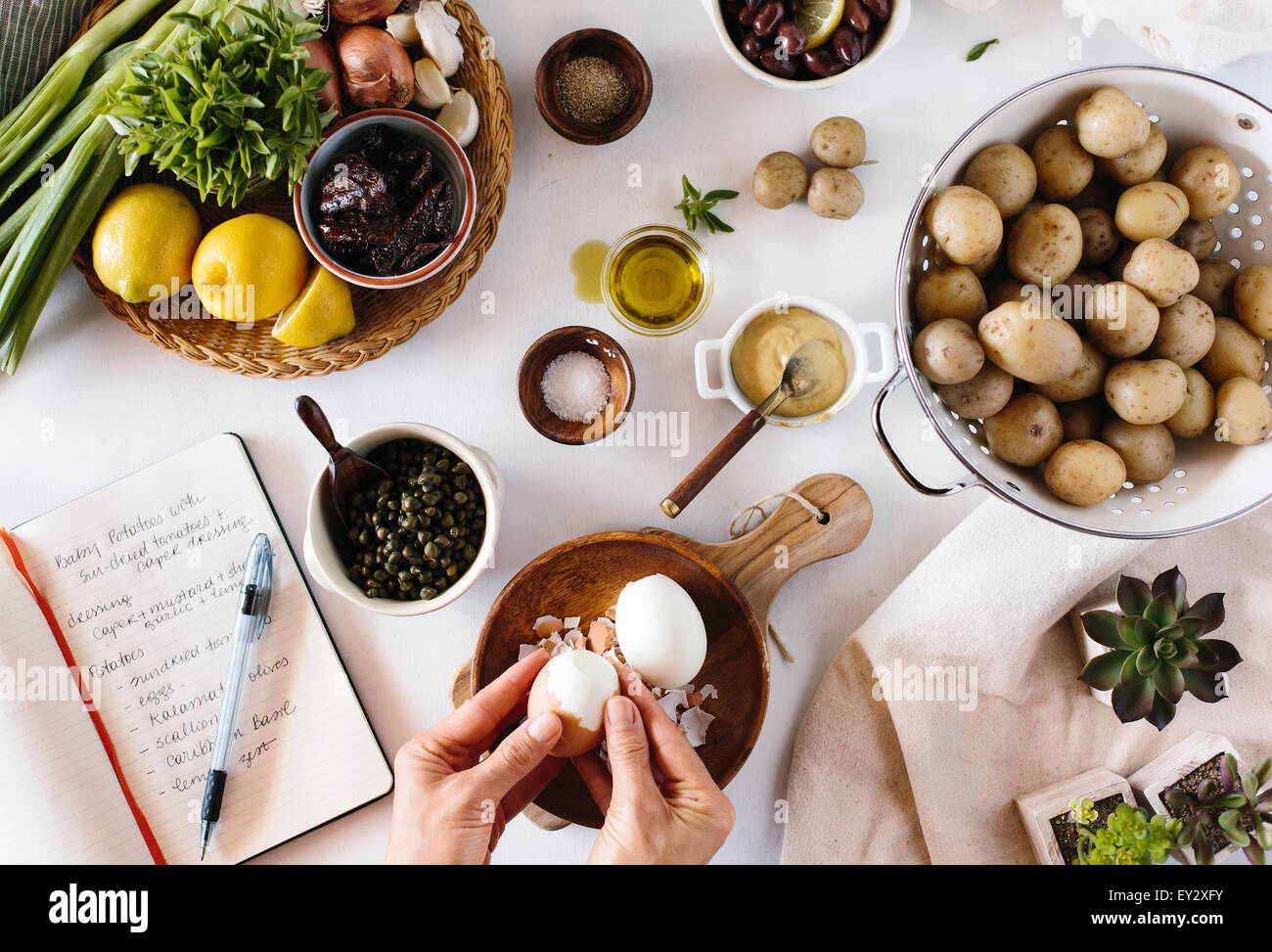 A person is peeling eggs for a baby potato salad Stock Photo
