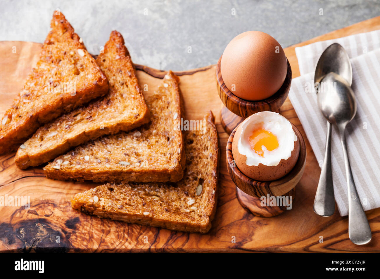 Boiled eggs for breakfast in olive wood egg cups Stock Photo