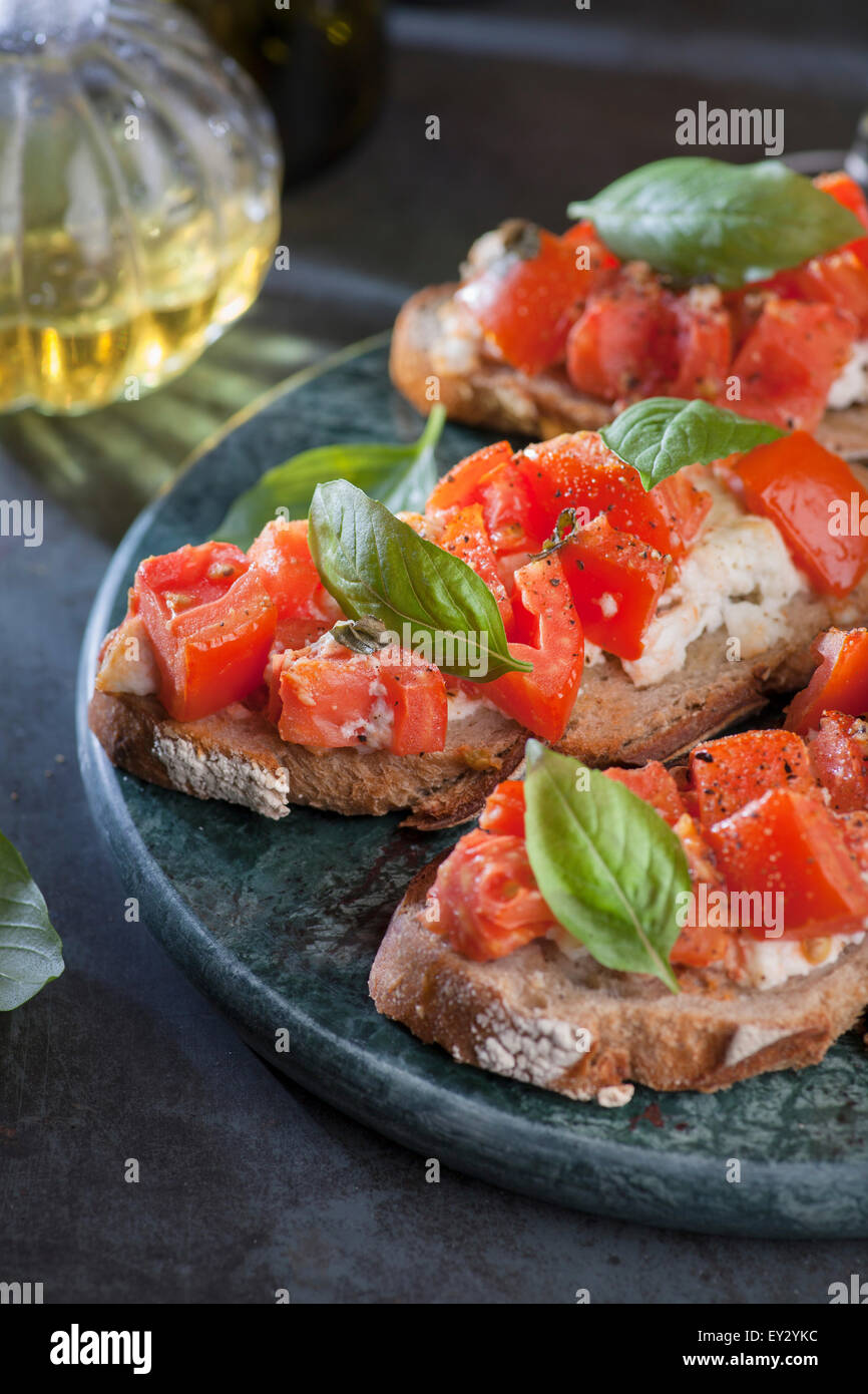 Italian tomato bruschetta with basil and olive oil on crusty slice of bread Stock Photo
