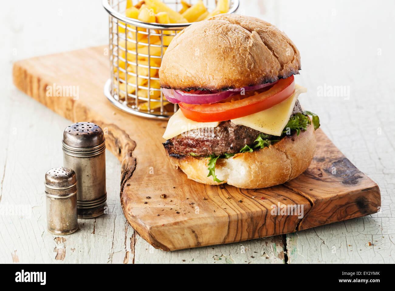 Burger with meat and French fries in basket on wooden background Stock Photo