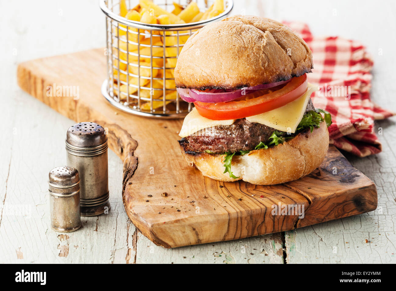 Burger with meat and French fries in basket on wooden background Stock Photo