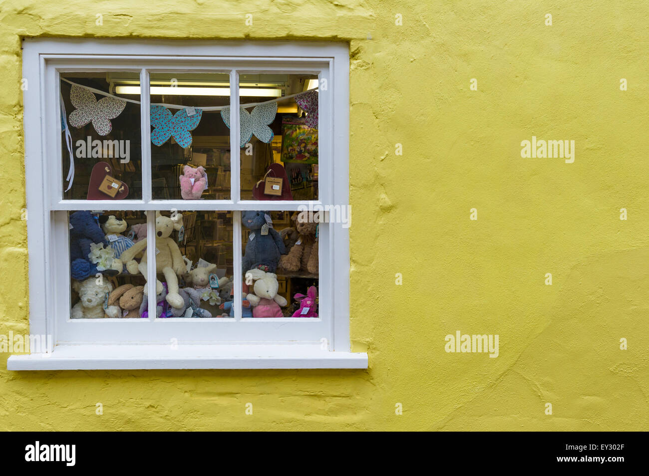 An assortment of teddy bears, rabbits and other stuffed animals in a window for sale. Stock Photo