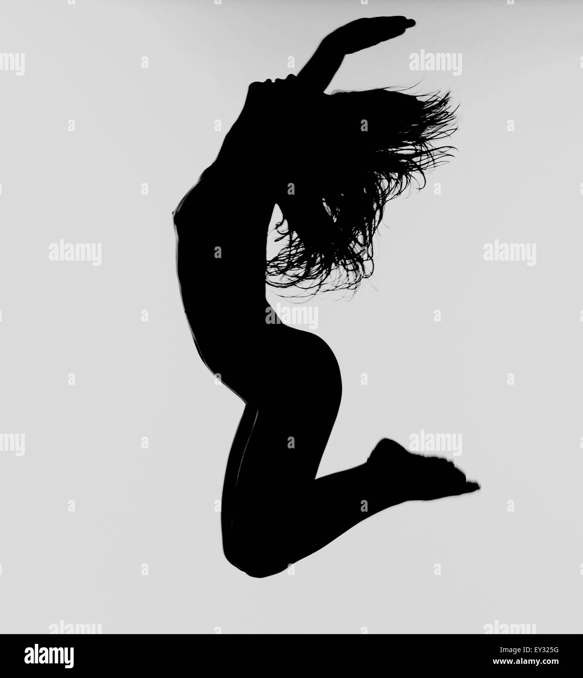 Female Silhouette with arms outstretched, jumping, yoga, meditation, energy, reiki, live, new, yes, happy Stock Photo