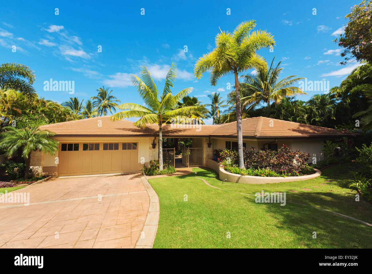 Tropical Luxury Home, Exterior View with Green Lawn and Driveway Stock Photo