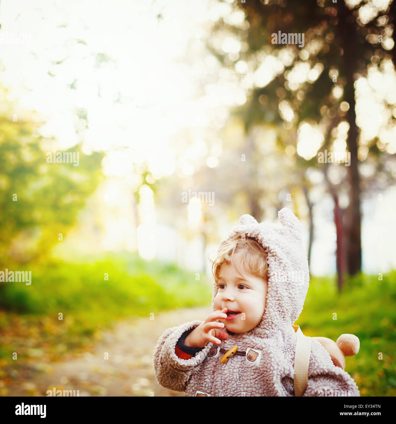 Funny Shy Little 2 year old Boy Giggling in the Park at the Sunset. Happy Childhood Concept. Space for your Text. Instagram Vint Stock Photo