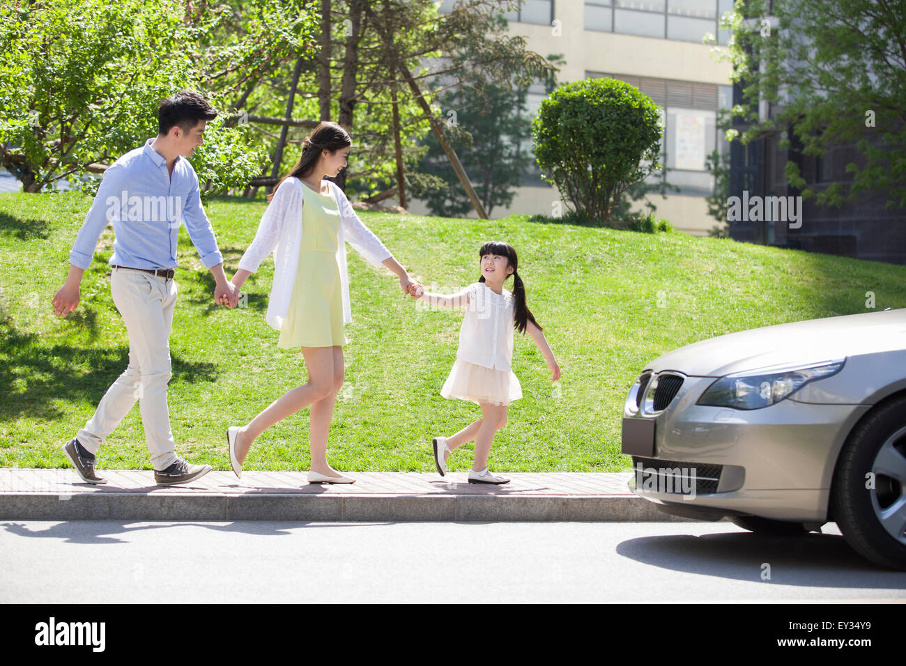Happy young family holding hands walking Stock Photo - Alamy