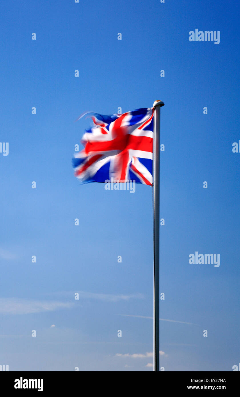 Union Jack flag flying in the wind against a blue sky Stock Photo - Alamy