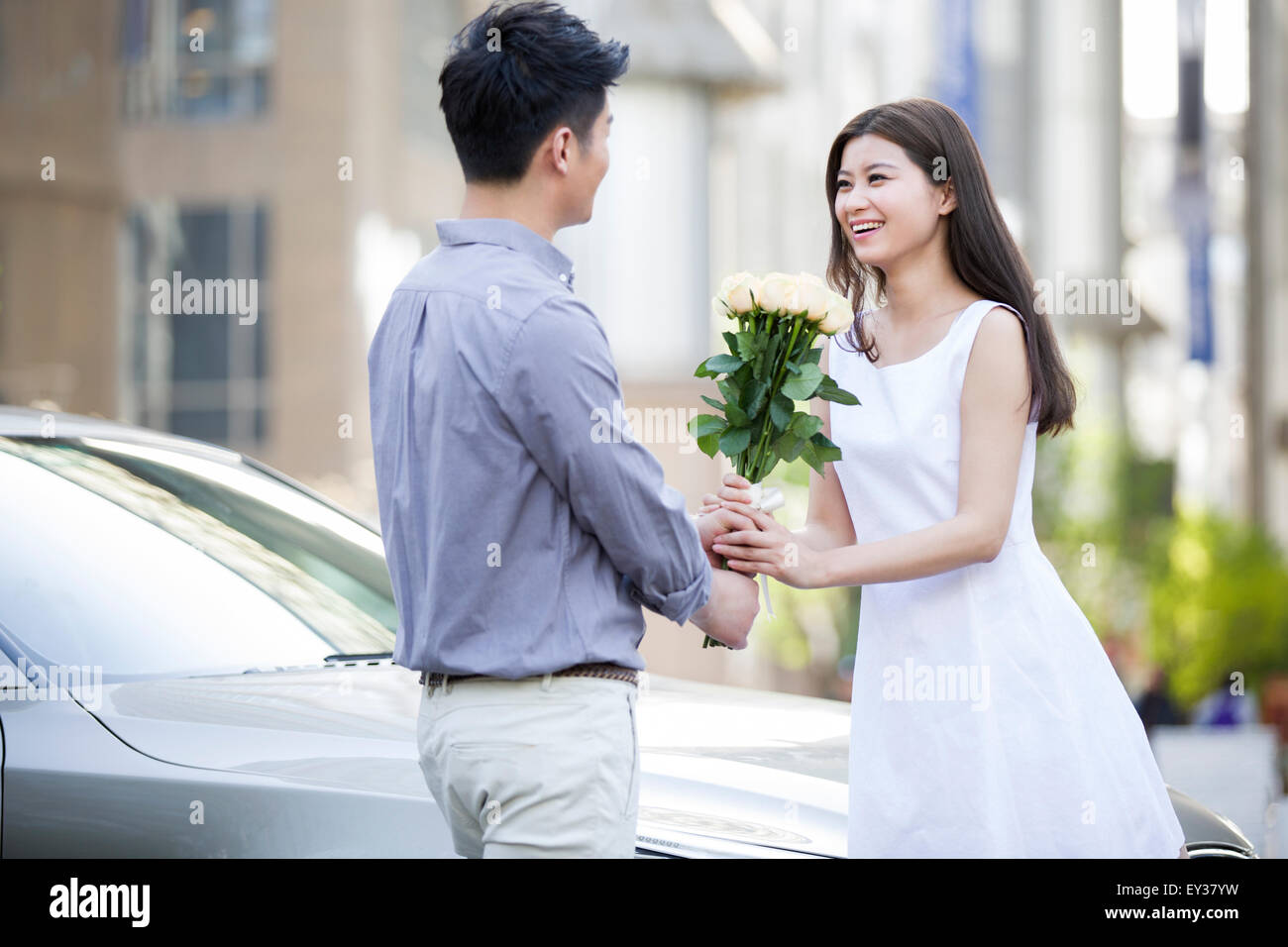 Young man giving flowers to girlfriend Stock Photo Alamy